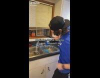 Guy blue shirt black cat washing knife stays and slashes the air 