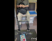 Man on train playing scratcher across seat 