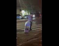 Man dragging air condition unit on street