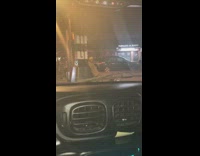 Brown jacket person rubs back against pole 