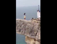 Woman yellow dress poses at the cliff
