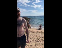 Two women photoshoot behind man at beach