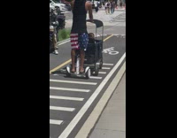 Guy rides Segway while pushing his in a stroller 