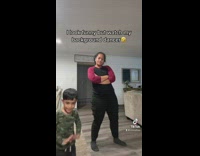 Woman dances while her son copies her