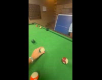 Woman hits cue ball towards the camera