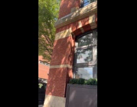 Man cleans building window no ladder around