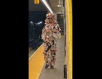Man with body covered in colorful notes money paper walks in subway station