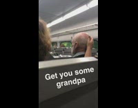 woman rubs head of old man sitting next to her