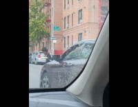 Man blocks cars while eating on street