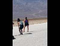 Lady at Badwater Basin Poses in front of Mountains 
