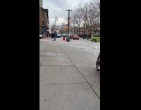 Elmo sits against a trashcan