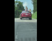 Two women photo shoot roof and window red car