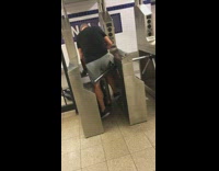 Man gets stuck with suitcase luggage in subway station turnstiles then breaks free