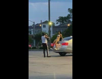 Lady in metallic bikini sits on back of car for photos 