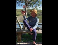 Man holds a bird feeder with birds approaches it