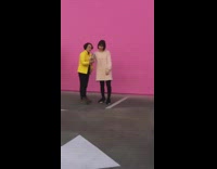 Large group of women taking pictures pink wall