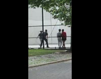 Police officer plays racquetball with boys at the park