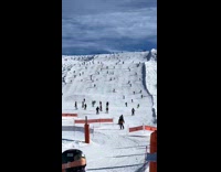 Large group skiing down hill