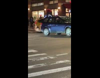 Crazy man jumps from the roof of a taxi onto the roof of a moving van in the middle of the street