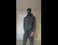 Guy black hoodie and black ski mask walks up to white door 