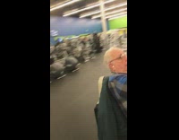 Old man blue plaid shirt sits on bike machine and sleeps at the gym