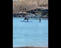 Man exercises on paddle board for video