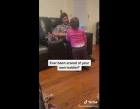 Baby girl in pink shirt picks up case scares dad on couch