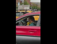 Guy in red car sitting in traffic dancing with his shakers