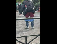 Man pants around legs red boxers looking at floor