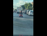 Collab WINY - Man rides mobility scooter on road 