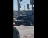 Woman with headphones dance near the stoplight on the sidewalk