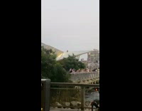 Guy sits on top of building near bridge 