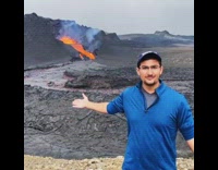 Guy Talks About Erupting Volcano Behind Him 