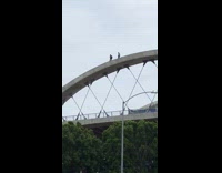 Two people walk on dangerous bridge 