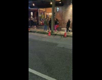 Woman pink pants carry street sign night