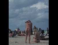 Blonde Lady in Black Bikini Sits on Sand for Photos 