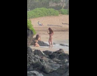 Woman black bikini pose on beach rocks