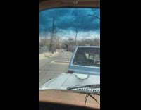 man pushing blue van on street