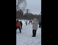 Person riding a foldable chair with skis attached on snow