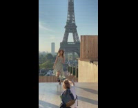 Woman gray polka dot dress sway with Eiffel tower behind