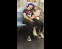 Two people napping on subway train on each other