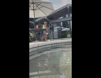 Girl in bikini does little jump on scooter around pool