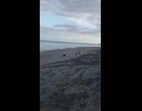 Black dress girl lays back beach sand 
