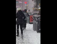 Guy cross country skiing near times square 
