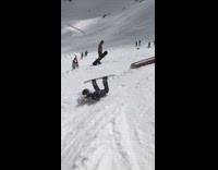 Snowboarder grinds on big tube falls 
