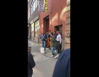 Guys sing a cappella outside on sidewalk 