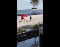 Woman in red dress films at beach Part 2