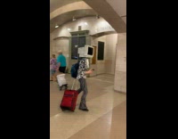 Collab WINY - Man with computer monitor walks at station