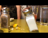 Salt shaker balanced on corner yellow table
