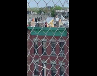 Red tank top guy juggles rooftop 